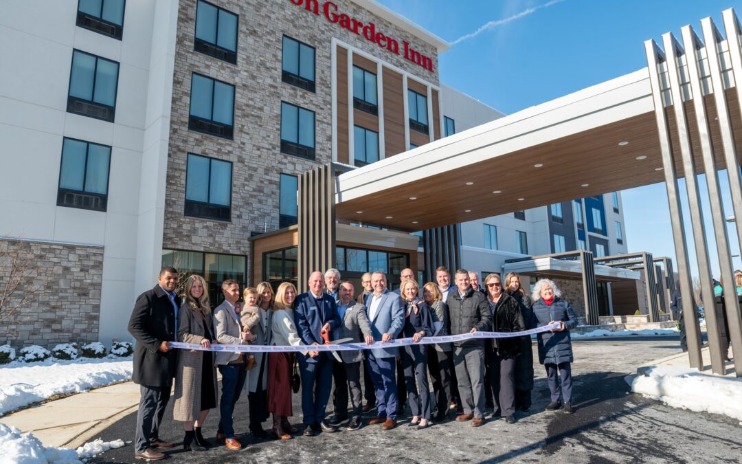 Group of people cutting a ribbon outside a Hilton Garden Inn hotel